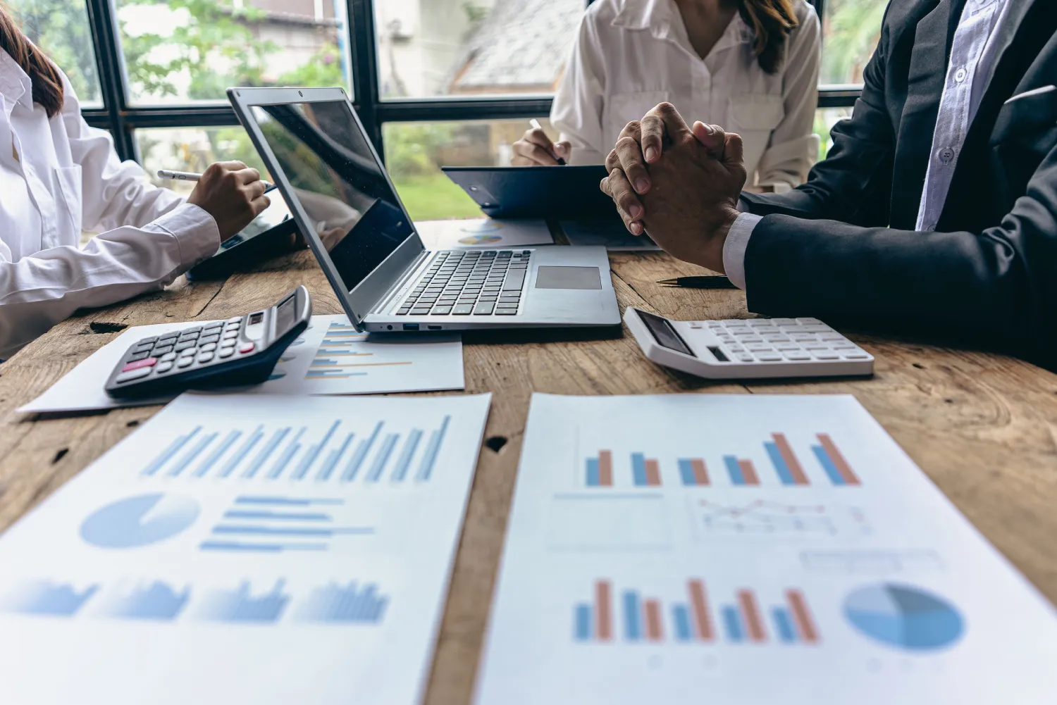 Services M&A _ Financing Group of businessmen holding smart pen discussing in group meeting at table in modern office with graph papers and laptop Strategic Planning, Business Collaboration and Brainstormi