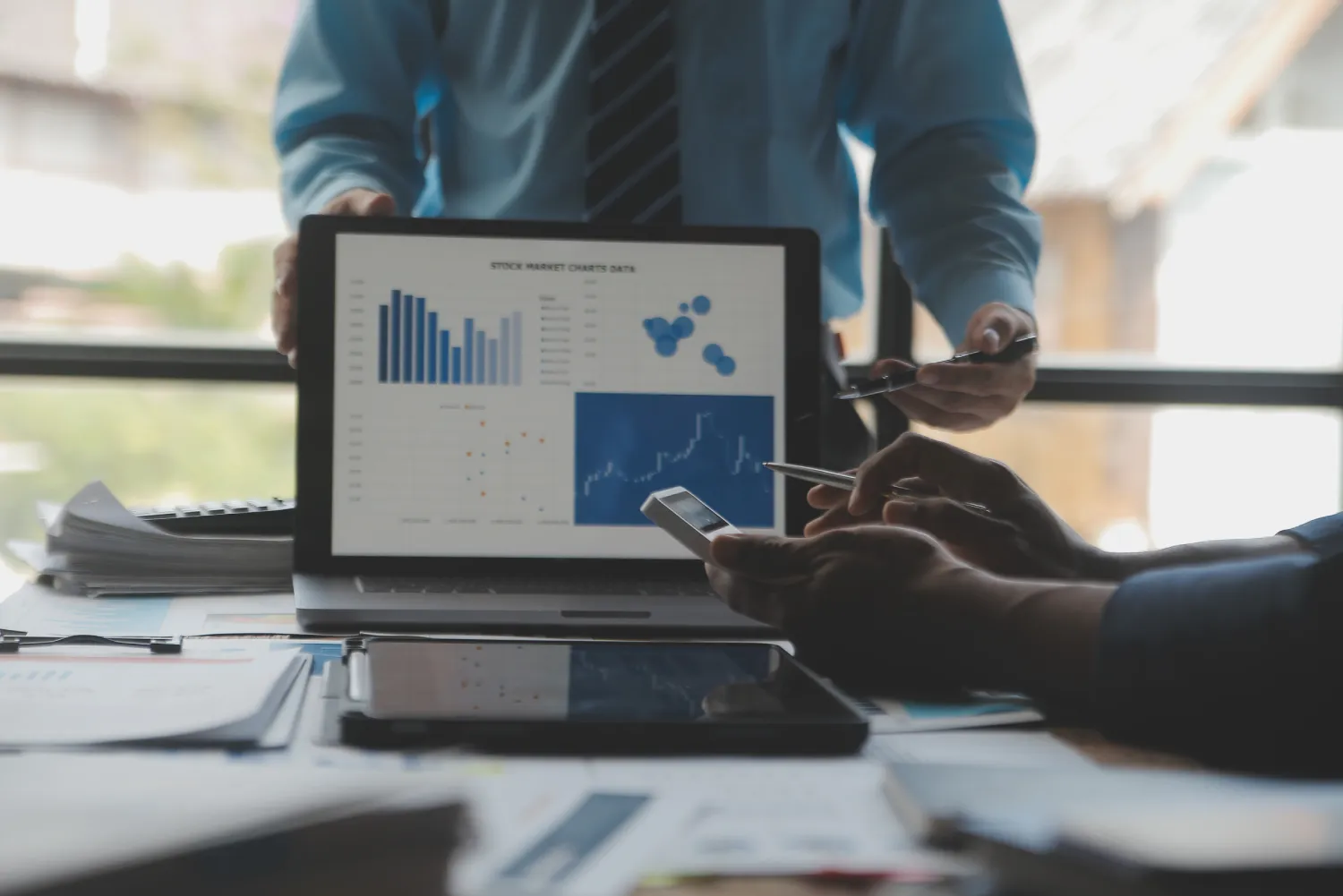 Services Operational Improvement Financial analysts analyze business financial reports on a digital tablet planning investment project during a discussion at a meeting of corporate showing the results of their successful teamwork.